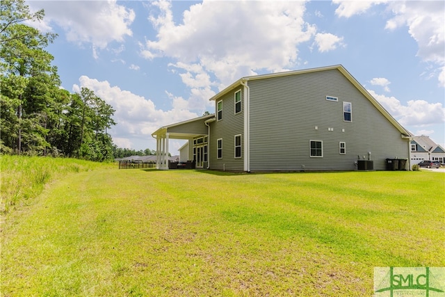 view of side of property with a lawn and central AC unit