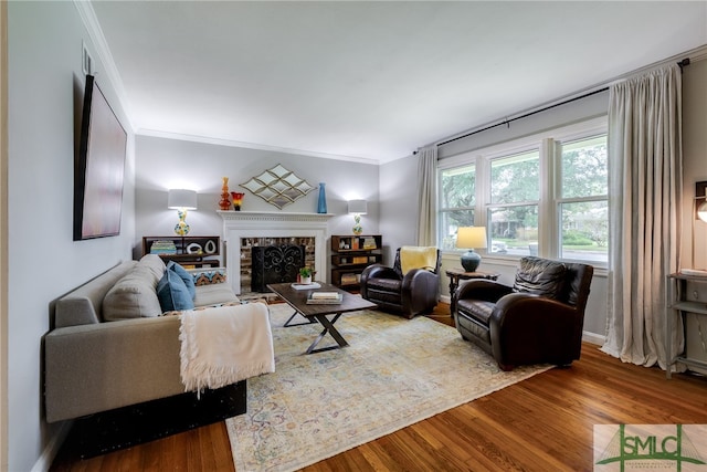 living room featuring crown molding, a brick fireplace, and hardwood / wood-style flooring