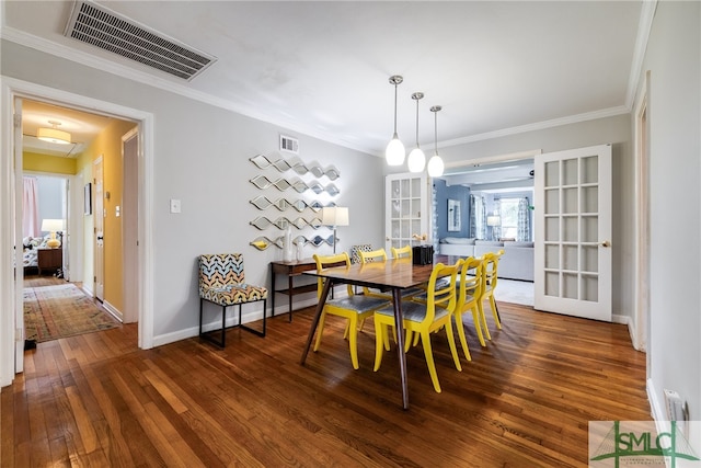 dining space with dark hardwood / wood-style floors, crown molding, and french doors