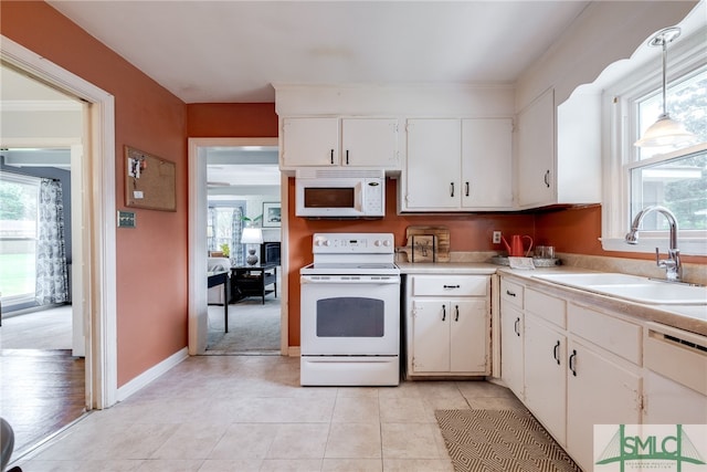 kitchen with hanging light fixtures, sink, white appliances, and light tile patterned flooring