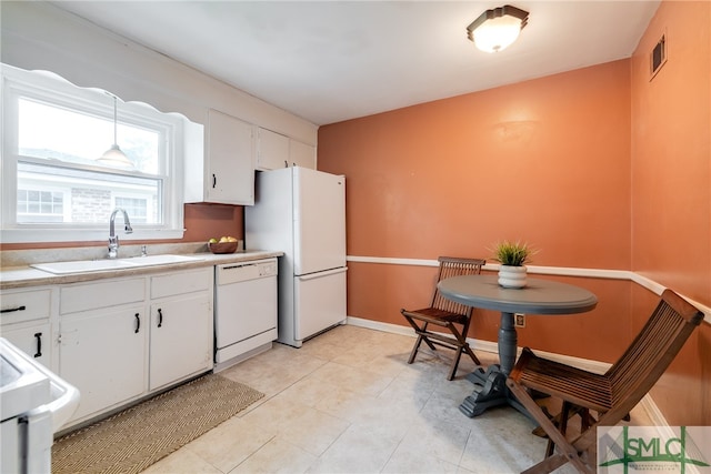 kitchen with white cabinetry, light tile patterned floors, white appliances, and sink