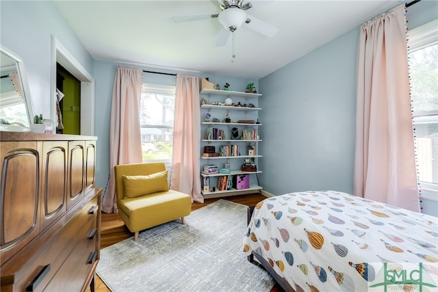 bedroom featuring multiple windows, ceiling fan, and hardwood / wood-style floors