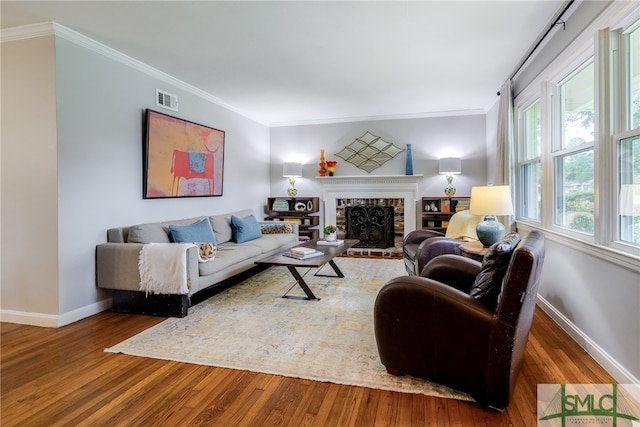 living room featuring ornamental molding, hardwood / wood-style flooring, and a fireplace