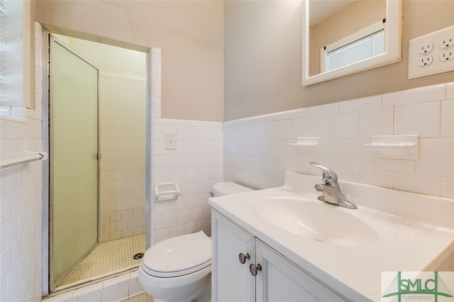 bathroom featuring vanity, toilet, tile walls, and a shower with shower door