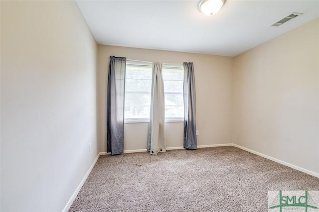 empty room with carpet floors, baseboards, and visible vents