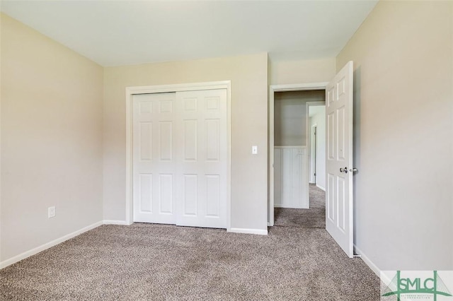 unfurnished bedroom featuring carpet floors, baseboards, and a closet