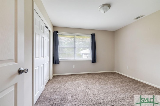 unfurnished bedroom with carpet floors, baseboards, visible vents, and a closet