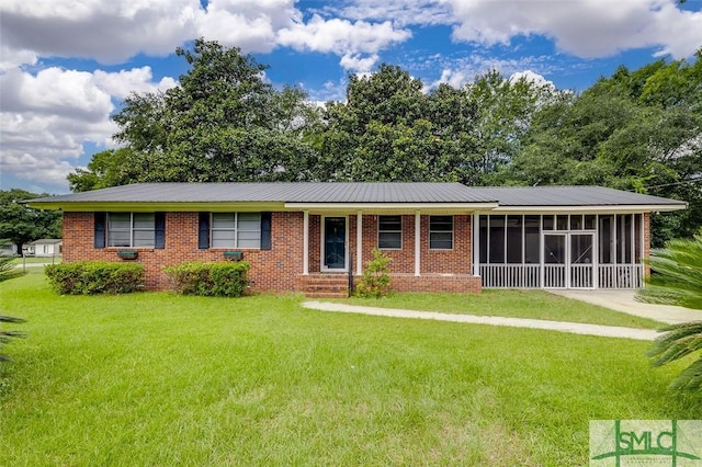 single story home featuring a sunroom, a front lawn, and brick siding