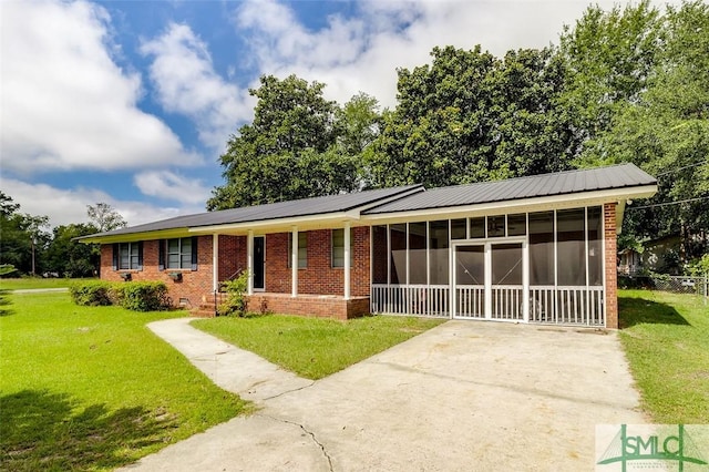 single story home with a front lawn, brick siding, a sunroom, crawl space, and driveway
