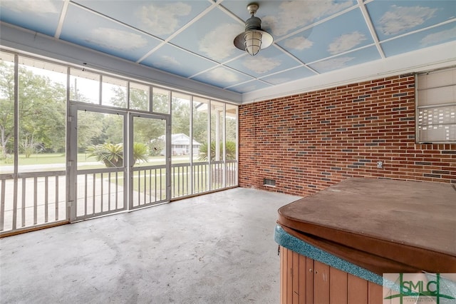 unfurnished sunroom with ceiling fan