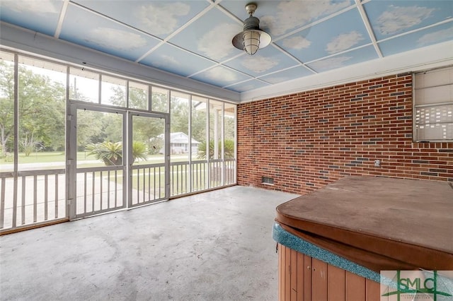 unfurnished sunroom with a jacuzzi and ceiling fan