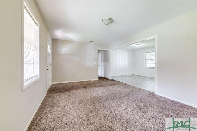 carpeted empty room featuring baseboards