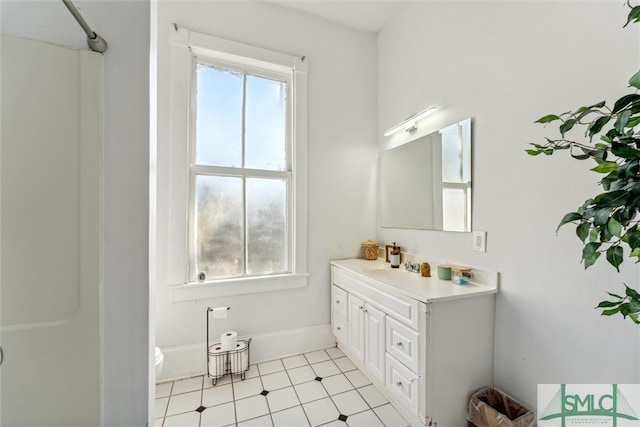 bathroom featuring tile patterned flooring, vanity, toilet, and walk in shower