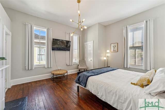 bedroom featuring multiple windows, dark hardwood / wood-style flooring, and a notable chandelier