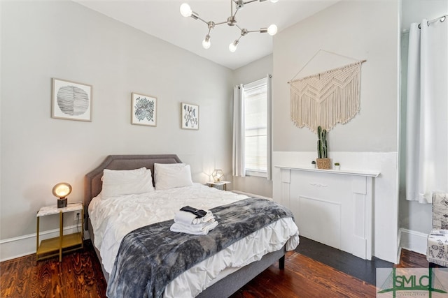 bedroom with dark wood-type flooring and an inviting chandelier