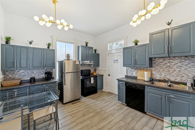 kitchen featuring black appliances, tasteful backsplash, a healthy amount of sunlight, and sink