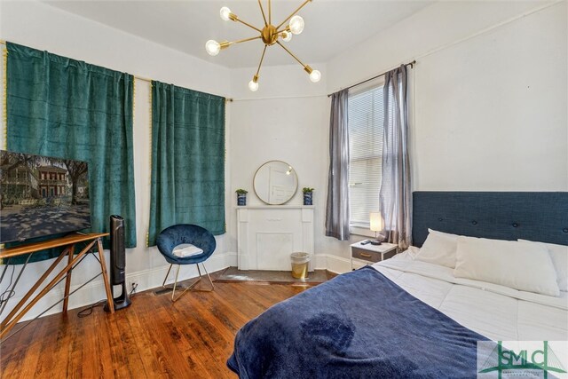 bedroom with an inviting chandelier and hardwood / wood-style flooring