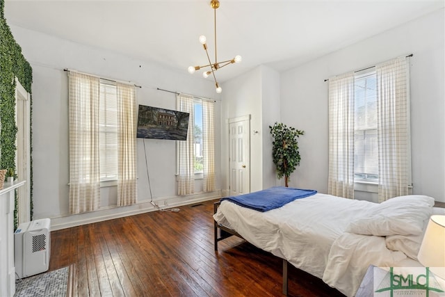 bedroom with dark wood-type flooring and a chandelier