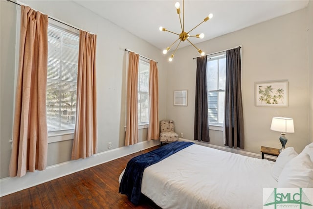 bedroom featuring dark wood-type flooring and a chandelier