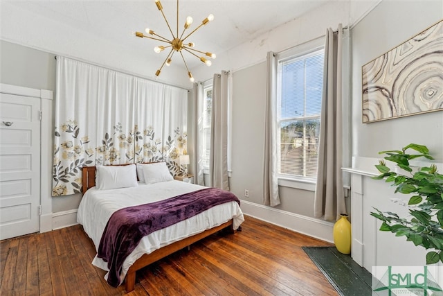 bedroom with multiple windows, a notable chandelier, and dark hardwood / wood-style floors