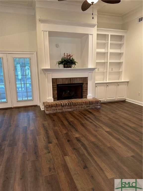 unfurnished living room with crown molding, dark hardwood / wood-style flooring, a brick fireplace, and ceiling fan