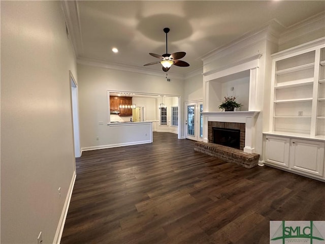 unfurnished living room with a brick fireplace, ceiling fan, ornamental molding, and dark wood-style flooring
