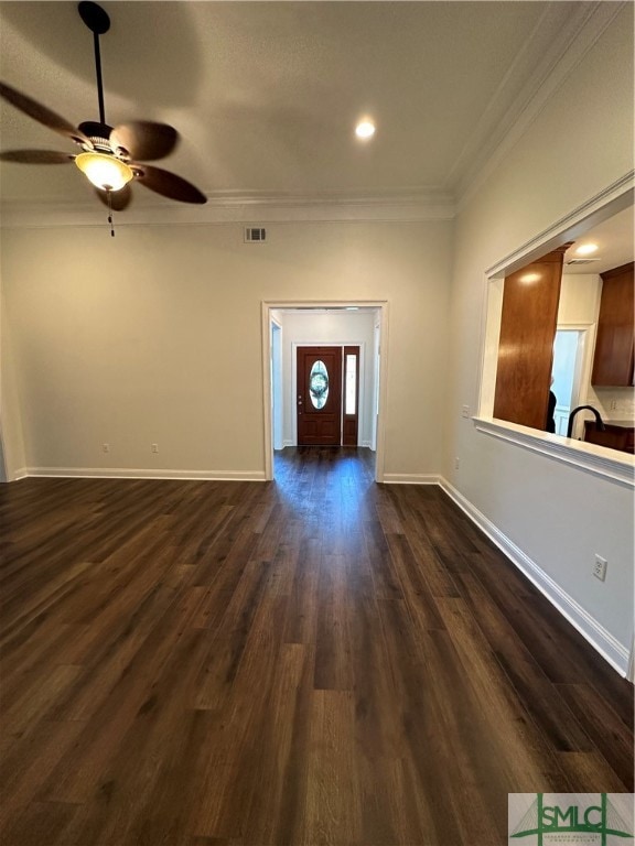 foyer entrance with crown molding, dark wood-type flooring, and ceiling fan