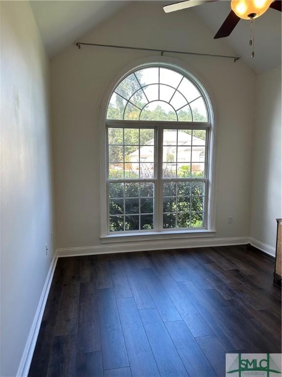 unfurnished room featuring dark wood-type flooring, lofted ceiling, ceiling fan, and baseboards