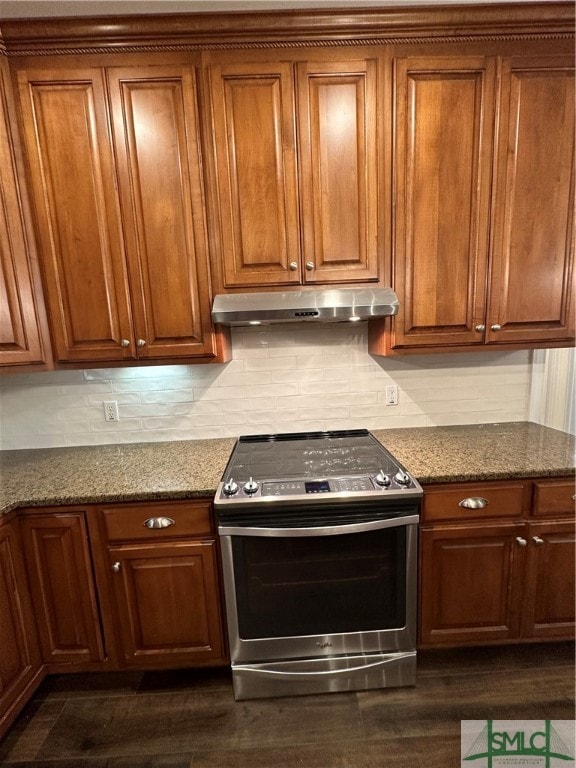 kitchen featuring dark stone countertops, dark wood-type flooring, backsplash, and electric range