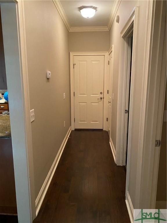 hallway featuring baseboards, dark wood-style flooring, and ornamental molding