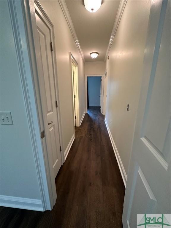hall featuring baseboards, ornamental molding, and dark wood finished floors