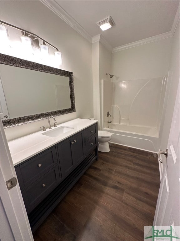 full bathroom featuring hardwood / wood-style floors, bathtub / shower combination, toilet, vanity, and ornamental molding