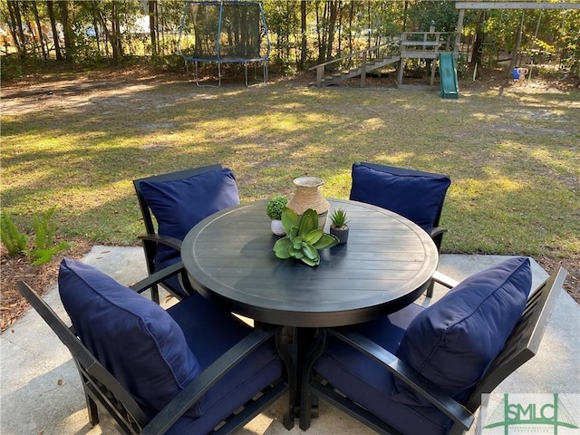 exterior space with a trampoline, a playground, and outdoor dining area