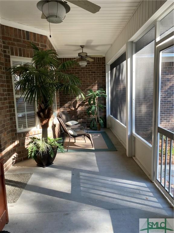 sunroom with brick wall and ceiling fan