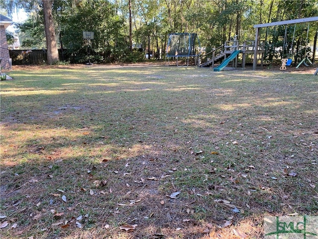 view of yard with a playground and a trampoline