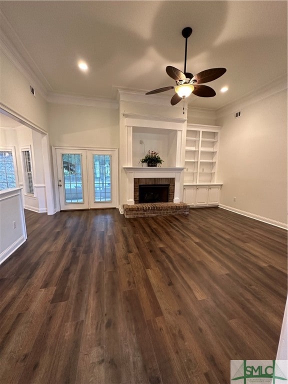 unfurnished living room featuring ceiling fan, dark hardwood / wood-style flooring, crown molding, and a brick fireplace