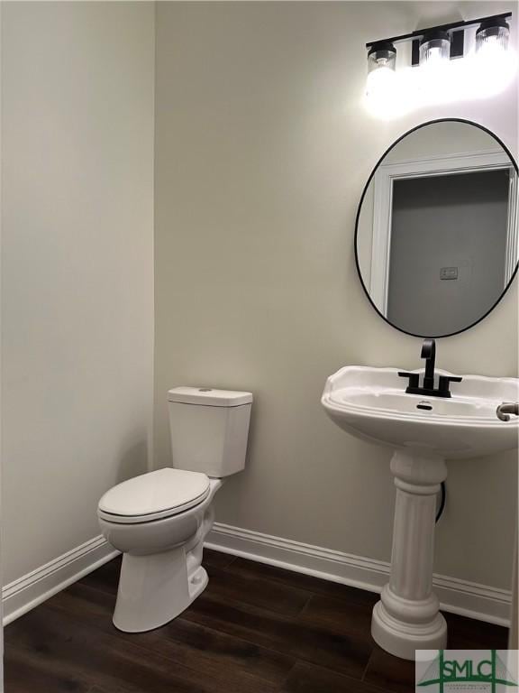 bathroom featuring baseboards, toilet, and wood finished floors
