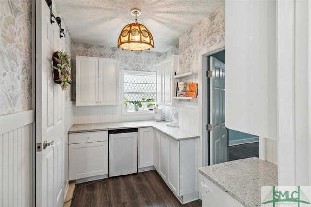 kitchen featuring a textured ceiling, dark hardwood / wood-style flooring, pendant lighting, light stone counters, and white cabinets