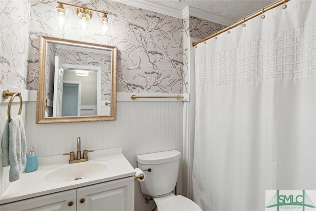 bathroom featuring a textured ceiling, vanity, toilet, and ornamental molding