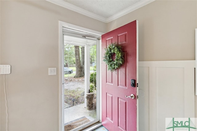 foyer entrance with crown molding and a textured ceiling