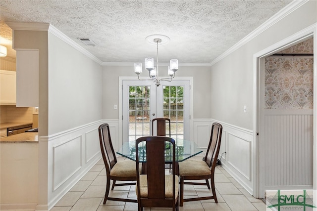 dining space with light tile patterned floors, crown molding, and a textured ceiling