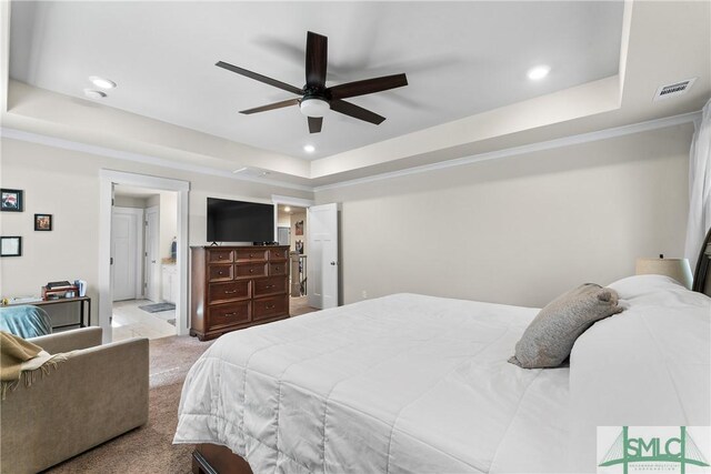 carpeted bedroom featuring a raised ceiling and ceiling fan