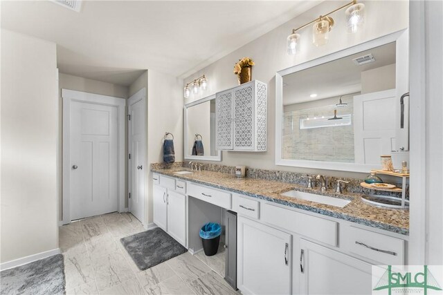 bathroom with vanity, a tile shower, and tile patterned floors