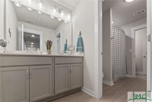 bathroom with vanity, toilet, a shower with shower curtain, and hardwood / wood-style floors