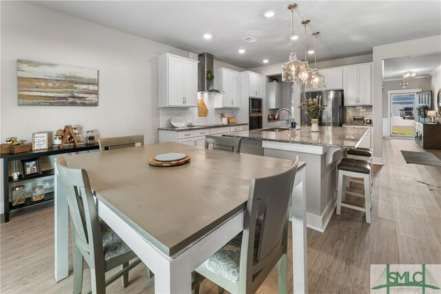 dining area with light hardwood / wood-style flooring and sink