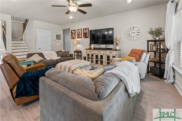 living room featuring ceiling fan and light hardwood / wood-style floors