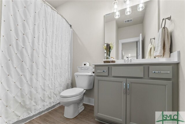 bathroom featuring vanity, toilet, wood-type flooring, and curtained shower