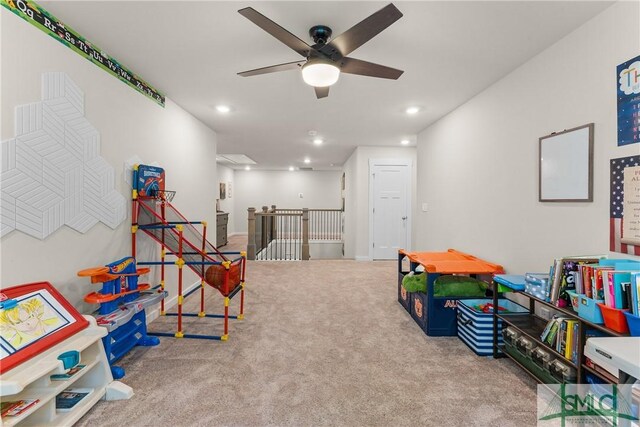 recreation room with ceiling fan and light carpet