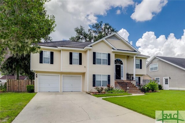 raised ranch featuring a garage and a front lawn