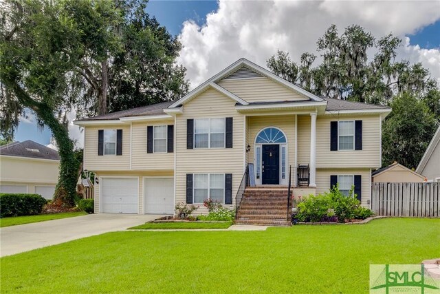 raised ranch with a garage and a front yard